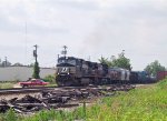 NS 9358 leads a train northbound past an empty woodchip train